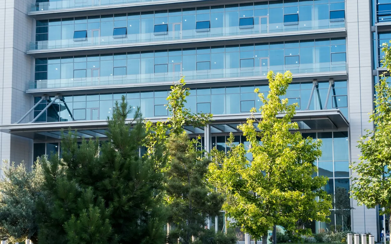 Glass-fronted office building with trees in front